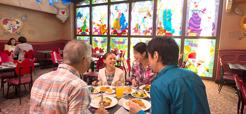 東京ディズニーランドのファンタジーランドにあるレストラン「クイーン・オブ・ハートのバンケットホール」で家族で食事をする様子