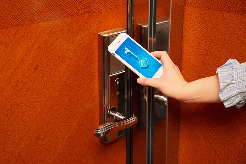 スマートフォンをかざして客室の鍵を開けている様子